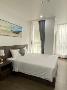 吉婆岛Sand Hotel的卧室设有一张白色大床和一扇窗户。