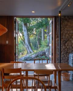 日出町kamenos Luxury Resort With Beautiful Scenery Hiji的一间带木桌和椅子的用餐室
