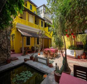 蓬蒂切里Luigi Villa的黄色的房子,设有池塘和桌椅