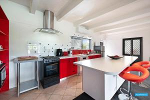 奥克兰玫瑰之家公寓的一间厨房,配有红色橱柜和台面