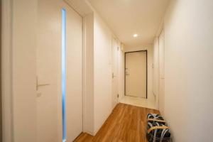 札幌Ferien 2LDK マスターベッドルーム・駐車場付的走廊设有白色墙壁、木地板和镜子