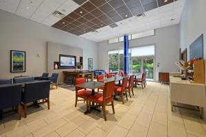 萨里Holiday Inn Express and Suites Surrey, an IHG Hotel的一间设有桌椅和窗户的等候室