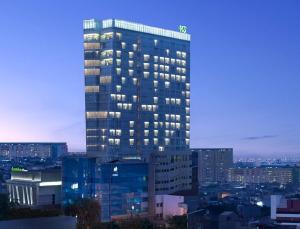 雅加达萨提卡高级哈亚乌鲁雅加达酒店的一座高大的建筑,城市里灯火通明
