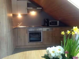 蒂蒂湖-新城Huis Rieslehof Appartement 12的厨房配有炉灶、微波炉和鲜花。