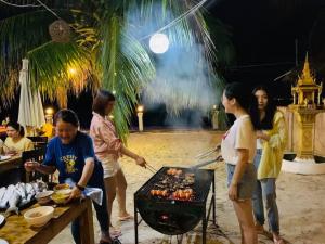 瓜隆岛Amor Resort Koh Rong的一群人站在烧烤架上