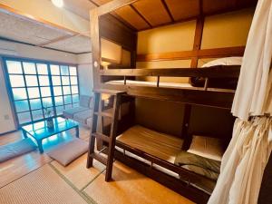 松本Guesthouse Azumaya的一间客房内配有双层床的房间