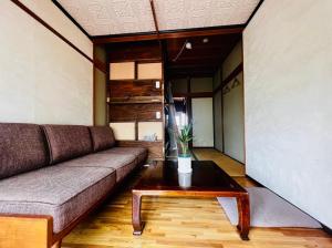 松本Guesthouse Azumaya的带沙发和咖啡桌的客厅