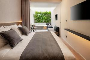 卡利诺岛Evanik Chic Hotel的一间卧室设有一张大床和一台平面电视。