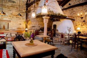 Santa Catalina de SomozaVia Avis的一间设有桌椅的用餐室和砖墙
