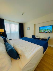 巴统Luxury Batumi Hotel的卧室配有带蓝色枕头的大型白色床