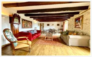 拉罗克加雅克Le Coin Tranquille的客厅配有红色的沙发和时钟
