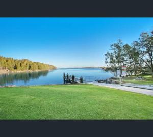 LakesideLake-view Retreat w Spa, nearby Beaches & Shopping in the Central Coast的草场水体景