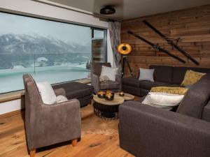 米特西尔Kitzb heler Alpenlodge Top A6 with private panoramic sauna的带沙发和大窗户的客厅