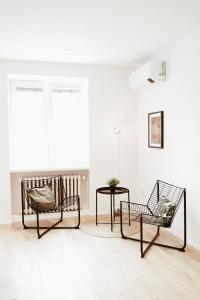 布拉迪斯拉发Schöndorf Hostel - virtual reception的客厅配有两把椅子和一张桌子
