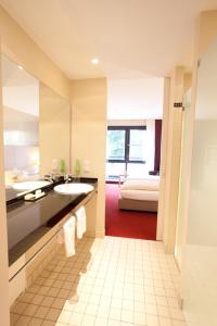 格罗瑙施普斯酒店的一间带水槽的浴室和一张位于客房内的床