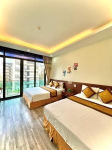 岑山Khách sạn Xanh Tốt FLC Sầm Sơn的酒店客房设有两张床和大窗户。