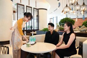 后川Emerald Ho Tram Resort的三人坐在餐厅桌子旁