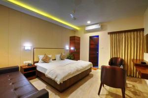 JalālpurHare Krishna Hotel的一间卧室配有一张大床和一张沙发