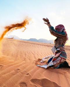 瓦迪拉姆Hasan Zawaideh Camp的坐在沙漠沙子里的女人