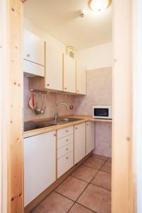 莫尔韦诺艾尔卡米纳托酒店的厨房配有白色橱柜、水槽和微波炉