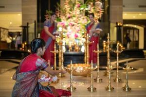 孟买塔亚地之涯酒店的站在带蜡烛的坛前的妇女