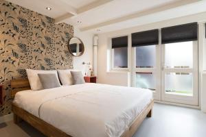 沃莫维尔Pakhuis aan de Zaan的卧室设有白色大床和窗户。