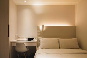 台北二十轮旅店西门町馆的一间卧室配有一张带桌子和椅子的床
