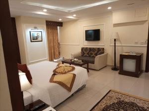 拉合尔Falettis Express DHA的酒店客房,配有床和沙发