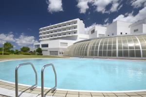 萨摩町Satsuma Resort Hotel的建筑前的一座带游泳池的建筑