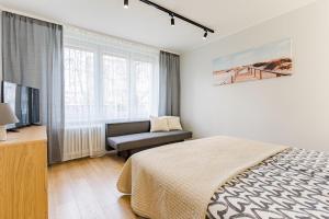 格但斯克Apartament Gdansk Stare Miasto的一间卧室配有一张床、一把椅子和电视