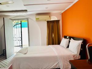 浦那Relaxing 3 Ac Room Near Pune Airport Kalyani Nagar的一间卧室配有一张白色的床和橙色的墙壁