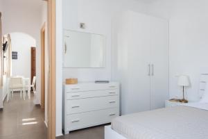 普拉提伊亚洛斯西弗诺斯伊里尼公寓式酒店的卧室配有白色梳妆台和镜子