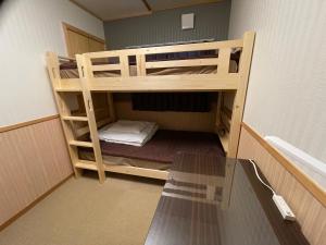 富士河口湖GuestHouse OC的配有一张桌子的客房内的双层床
