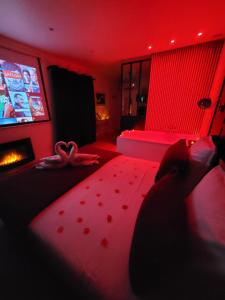 土伦Nuit d'évasion love room avec baignoire balnéothérapie的客厅设有红色的房间,配有沙发和电视