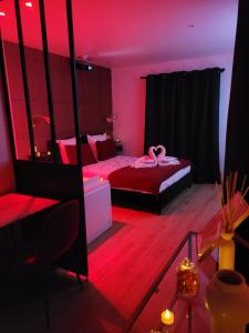 土伦Nuit d'évasion love room avec baignoire balnéothérapie的一间卧室配有一张粉红色照明床