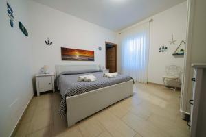 波尔图·埃尔科莱Il Poggetto di Porto Ercole的一间卧室配有一张床,上面有两条毛巾