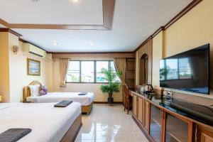 南芭堤雅La Casa South Pattaya Hotel的酒店客房设有两张床和一台平面电视。