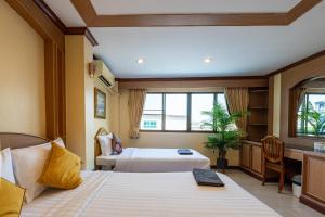 南芭堤雅La Casa South Pattaya Hotel的酒店客房设有两张床和窗户。