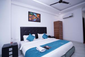 新德里Hotel Moon Taj Near Yashobhoomi Convention Centre的一间卧室配有一张带蓝色枕头的大床