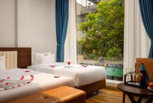 河内Casa Valentina Hanoi Hotel的酒店客房设有两张床和窗户。