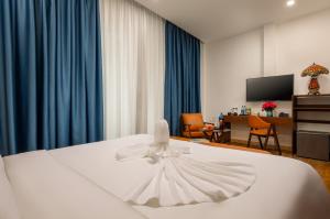 河内Casa Valentina Hanoi Hotel的一间酒店客房,配有白色的床和连衣裙