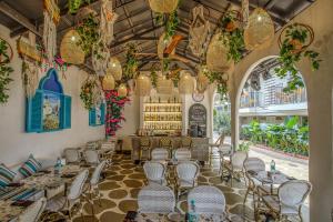 卡兰古特Quality Inn Ocean Palms Goa的一间带桌椅的餐厅和一间酒吧