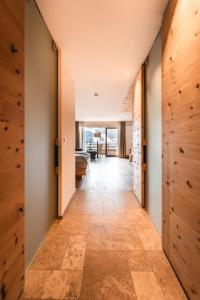 圣坎迪朵Naturhotel Leitlhof的走廊设有木镶板,走廊长,门上设有门