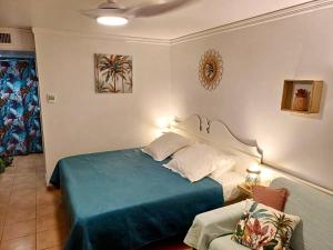 圣安尼Studio Ti Karanbol RDC vue mer dans Résidence de Tourisme的一间卧室配有一张床和一把椅子