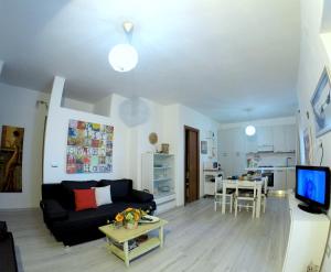 瓦雷多利亚Appartamento in villa的客厅配有黑色沙发和桌子