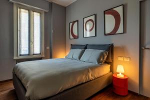 米兰Morigi 5 Vie的一间卧室配有一张大床和一盏红灯