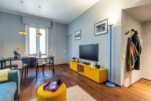 米兰Morigi 5 Vie的客厅设有黄色橱柜和电视