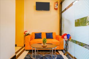 孟买FabExpress Kurla Inn的客厅配有橙色沙发和桌子