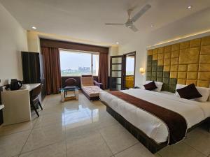 巴罗达Hotel Grand Darshan Vadodara的酒店客房设有一张大床和一张书桌。