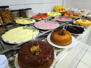 阿帕雷西达Pousada Santa Gianna的自助餐,包括许多不同类型的蛋糕和糕点